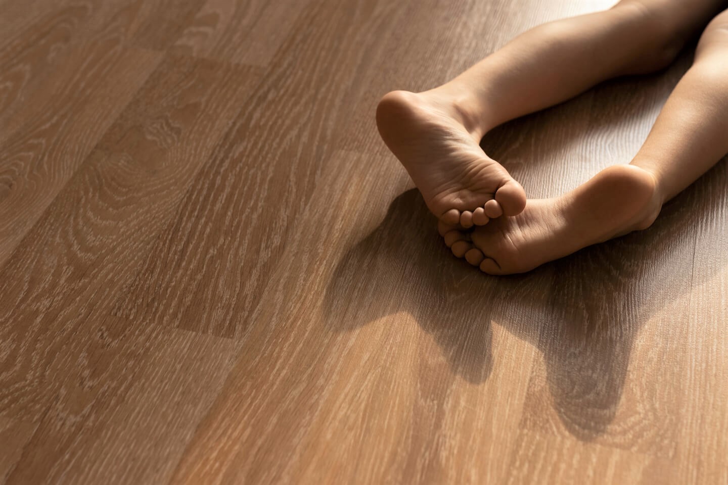 Little girls legs on a wooden floor